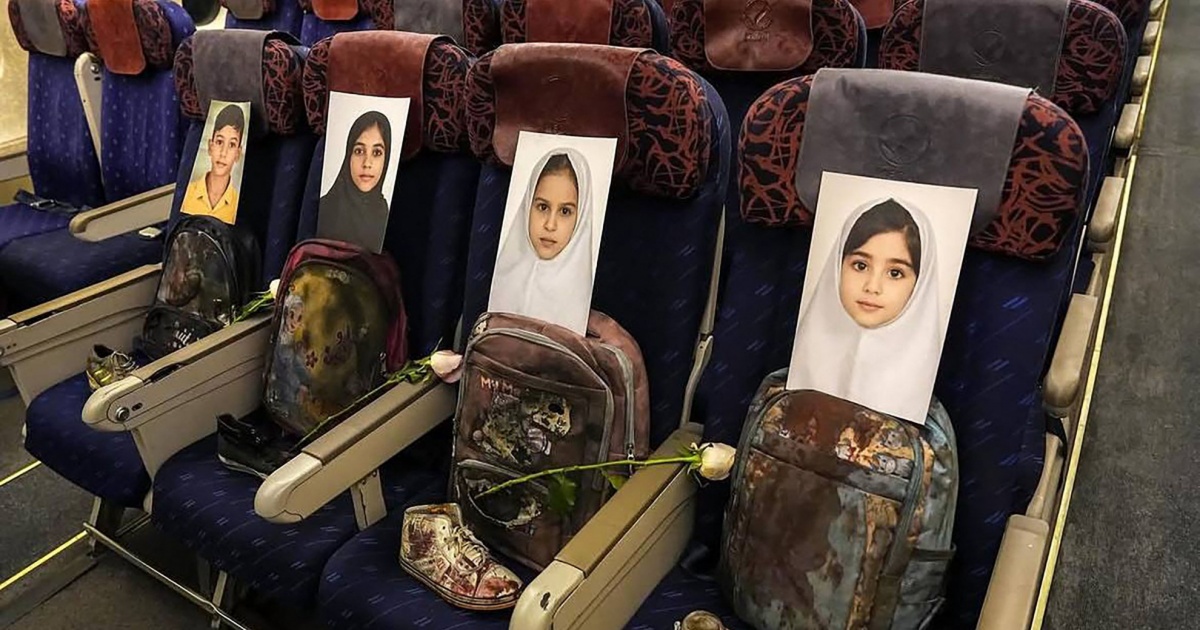 Un fiore bianco accanto alle foto dei bambini uccisi a Minab