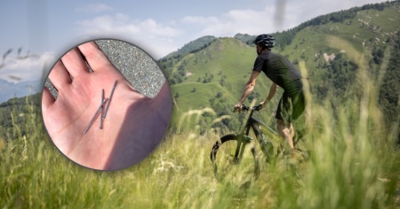 Chiodi sparsi sulla strada e ciclisti con le gomme forate